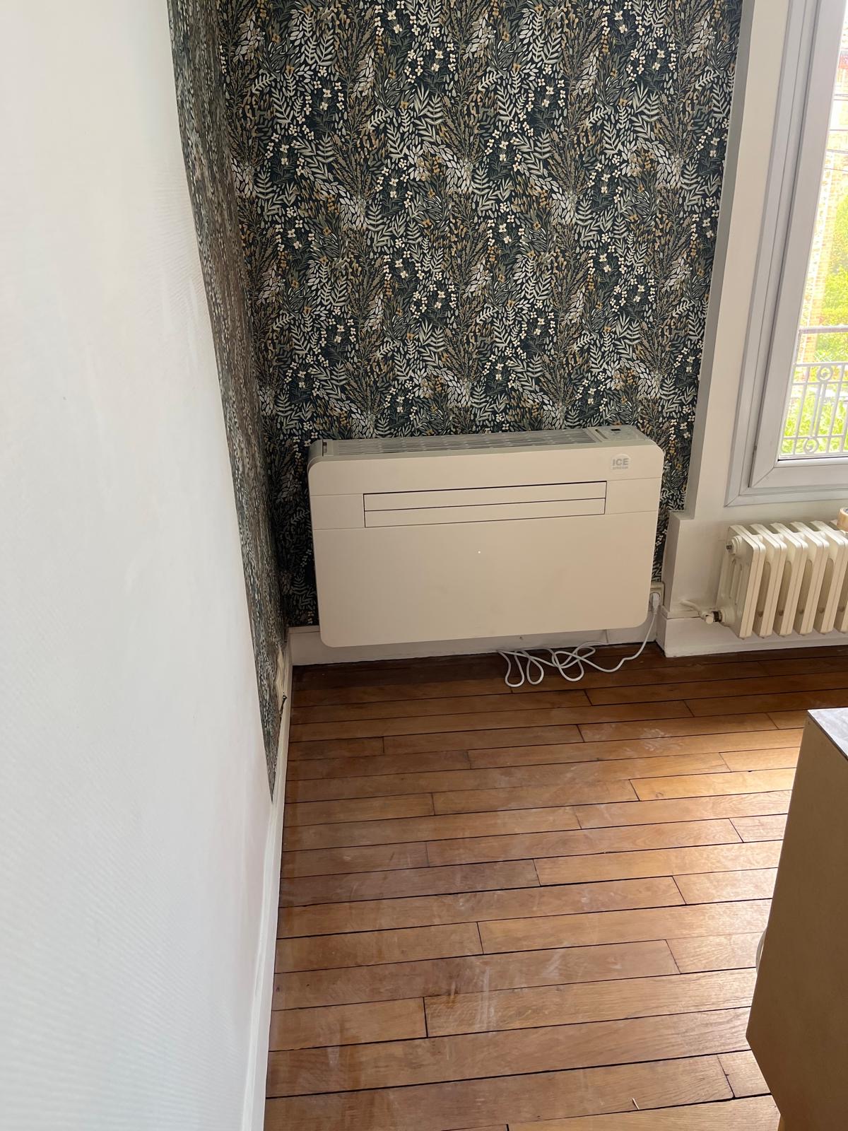 Console intérieure de climatisation installée sur un mur tapissé