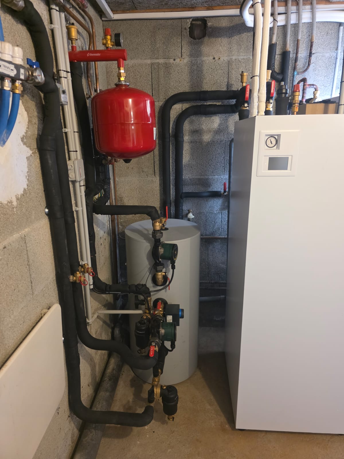 Local technique : module intérieur de pompe à chaleur, ballon tampon et tuyauterie calorifugée