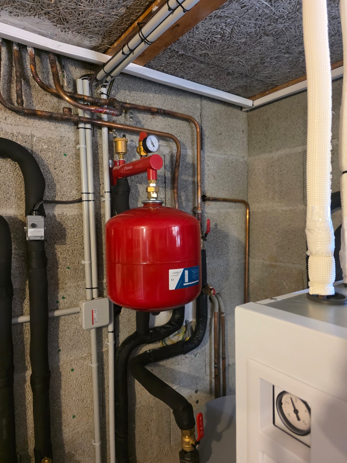 Vase d’expansion, purgeur et manomètre raccordés en cuivre, finitions du mur autour des percements
